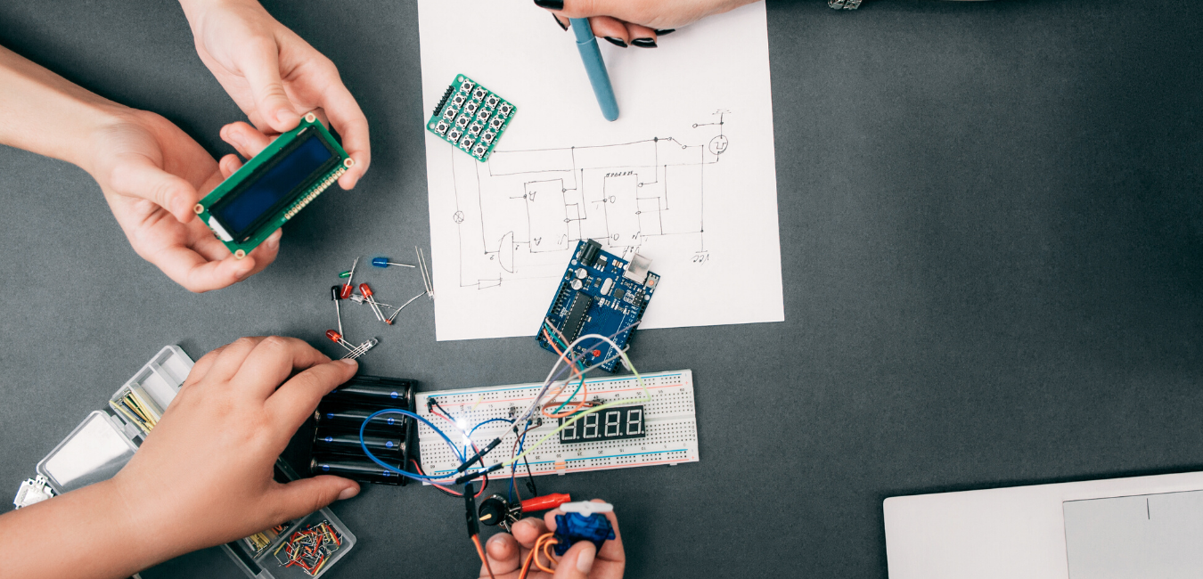 Students working at table with lans and computer parts